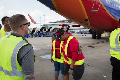 Southwest Airlines Houston-based flight crews arrive Houston Hobby Airport after being stuck in other cities during Hurricane Harvey on Friday, September 1, 2017. In lieu of a water cannon arch, the ground ops supervisors made a salute with a wall of belt loaders. Photo by Stephen M. Keller