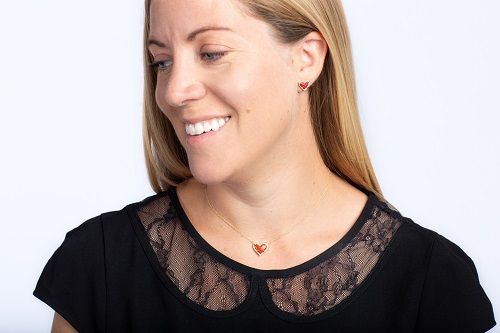 Southwest Employee Alyssa models  Store’s Kendra Scott Ari Heart Gold Pendant Necklace and Ari Heart Earrings in Southwest’s Warm Red--two exclusive pieces designed just for Southwest: