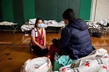 American Red Cross volunteer speaking with a Houston, Texas resident staying at a Red Cross shelter on Feb. 19, 2021, during the Texas winter storm.