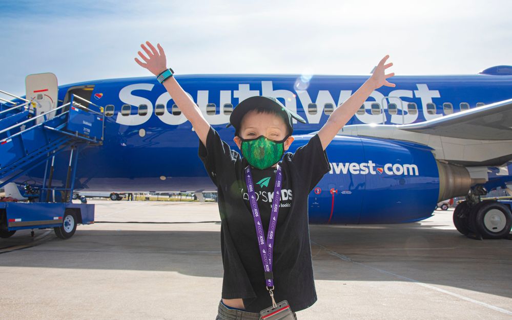 A child selected to go on the Kidd’s Kids trip poses in front of a Southwest Airlines aircraft.