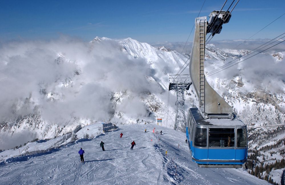 View of the mountains and a blue ski tram at Snowbird ski resort in Utah